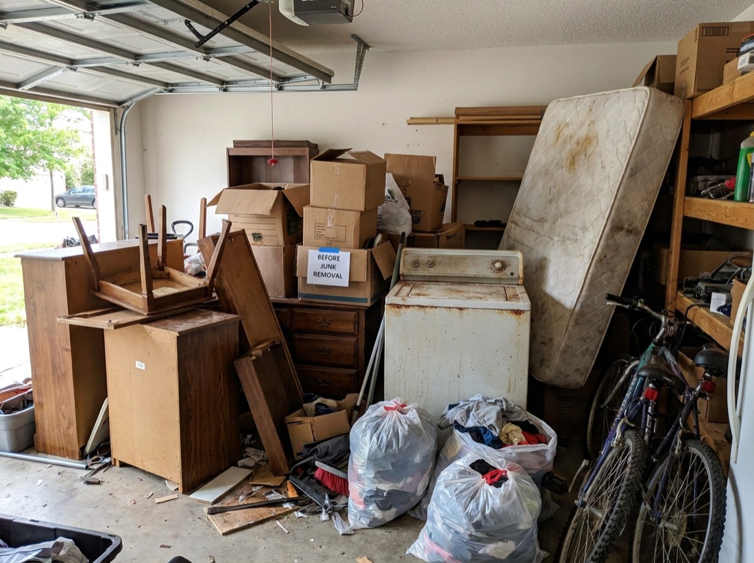 Cluttered garage full of junk before cleanout